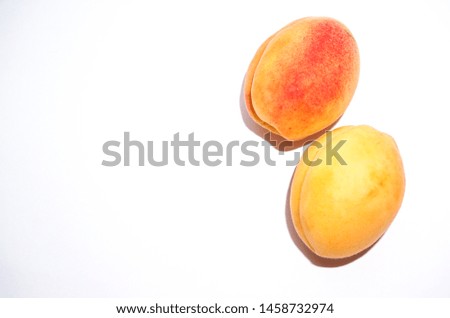two fresh apricots on a white background