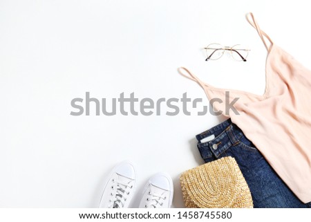 Casual fashion lookbook concept. Clothing and accessory items on white isolated background with a lot of copy space for text. Top view, flat lay, close up.