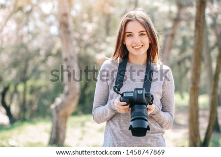 Beautiful female photographer working outdoors