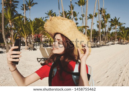    woman in hat with phone on the beach                            