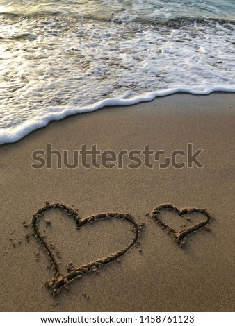 Two hearts on the sand in the influx