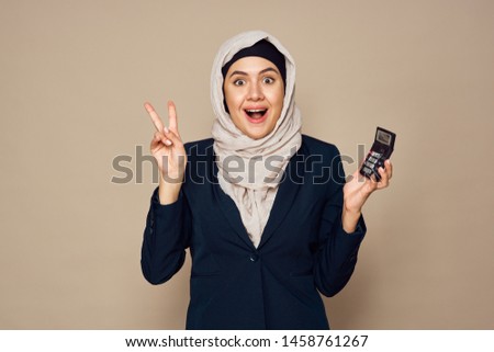 woman in a veil holding a calculator in her hand                               