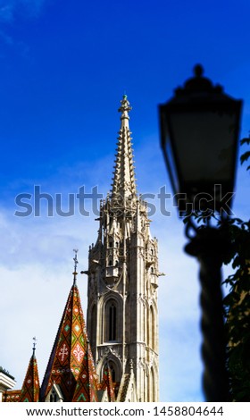 Blurred street lamp in front of Saint Matthias Church in the Fisehrman's bastion area of Budapest city in a clear blue sky day.