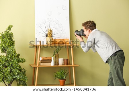 Teenage boy with photo camera at home