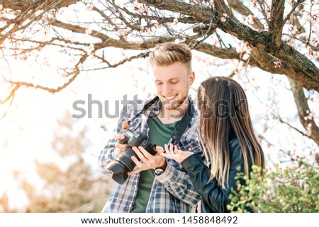 Professional photographer showing pictures to model outdoors