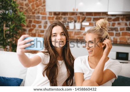 Two young girls making selfie at home.