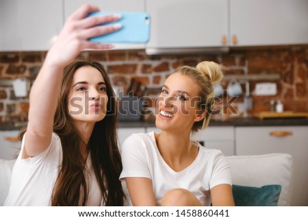 Two young girls making selfie at home.