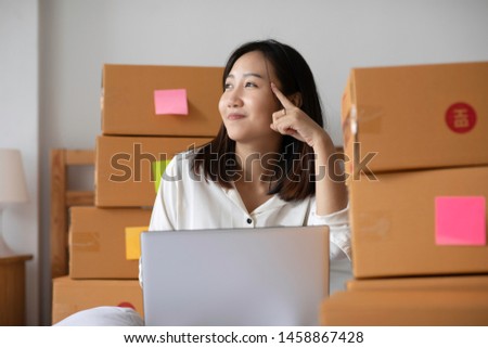 SME entrepreneur Young Asian women working with laptop thinking for marketing Online shopping at home,Happy with box for packaging in home,Own Business Start up for Business Online and Online shopping