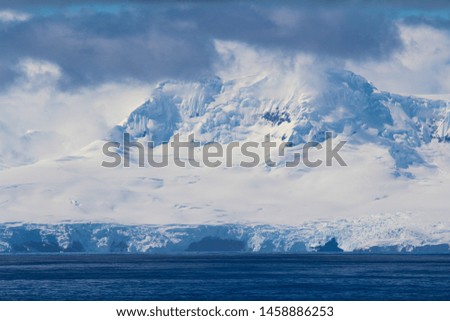 Snowy mountain on an island along the coasts of the Antarctic Peninsula, Antarctica