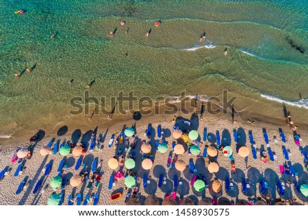 Aerial View of the Paradise Beach with colorful umbrellas, at Thassos island, Greece. swimming people in sea