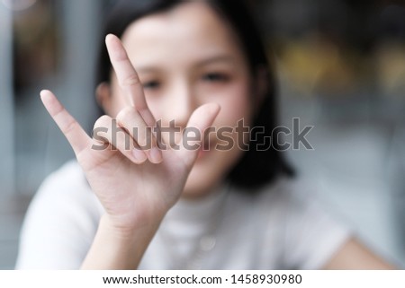 Asian girl show Love hand sign 