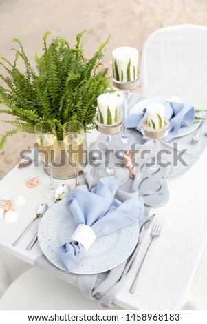 Beautiful table setting on the beach for romantic dinner for two. Wedding concept. Honey moon dinner.