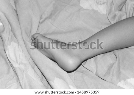 baby foot on the bed sheet close up