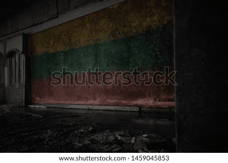 painted flag of lithuania on the dirty old wall in an abandoned ruined house. concept