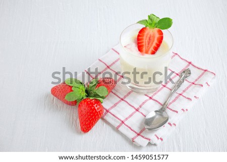 Healthy strawberry yogurt with fresh berries, oats spoon and mint on white wooden table. healthy breakfast. close up with copy space