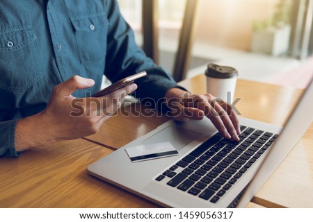 Hands of man are holding smart phones and using laptops computers are entering websites to buy products. Royalty-Free Stock Photo #1459056317