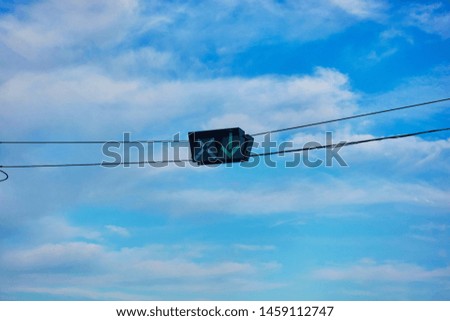 Road sign with wires against the sky indicating reversible traffic.