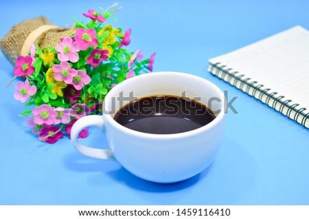 Notebook with a cup of coffee and a bouquet of flowers placed together