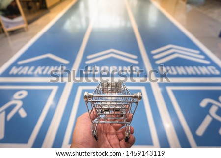 A hand holding cart model with running field background, Business competition, Marketing, Dealing concepts.