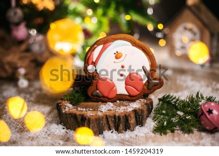 Holiday traditional food bakery. Gingerbread happy sitting Snowman or snowball in cozy warm decoration with garland lights.