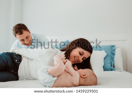 
Young and loving couple playing with their baby on the bed. Caring for and loving the little family member. Lifestyle