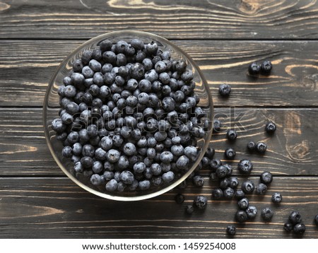 Blueberries close up in glass plate. Food Photography. Rustic wood background.