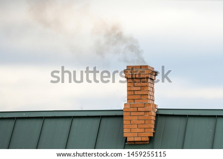Smoke from the chimney, heating. smoke billowing. coming out of a house chimney against a blue sky background Royalty-Free Stock Photo #1459255115
