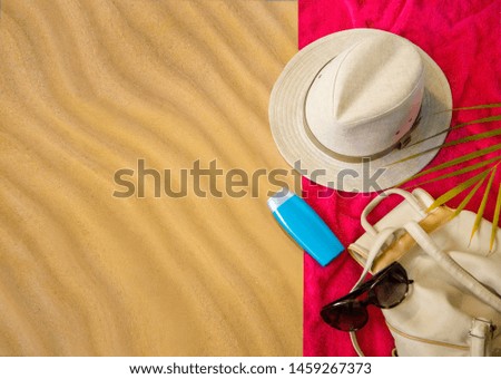 vacation, beach vacation texture of beach sand of a light yellow color.white hat , sunscreen beige .bag  on towel