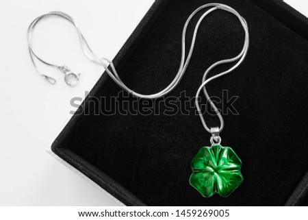 Green four leaf clover pendant in black jewel box closeup