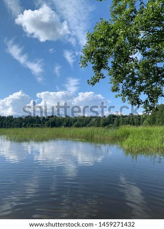 Summer scenery in Finland on a hot summer day. Blue sky with clouds and reflecting water.