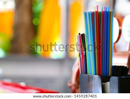 Multicolored tubes for a cocktail in a bundle on the bar with a place for text.