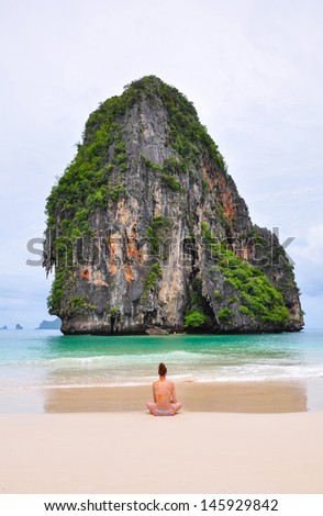 woman alone sit on the beach looking sea and island (Railay, Krabi province Thailand).