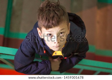 Boy with cute eyes looking at camera. Boy indoors photograph from upstairs