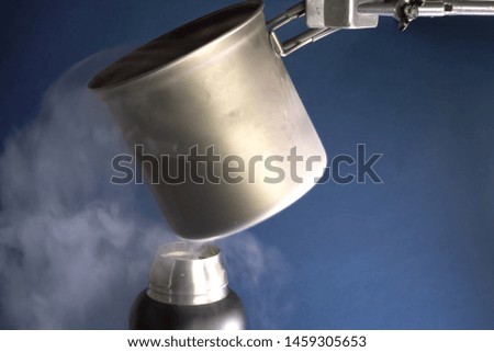 Liquid air, pouring liquefied air into a thermos.