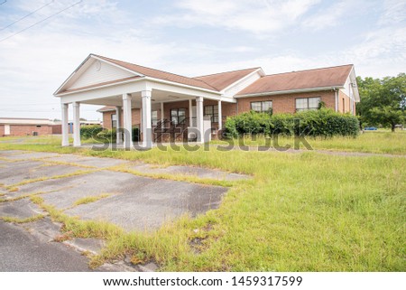A rundown residential and commercial property in a suburban area with a for lease sign.