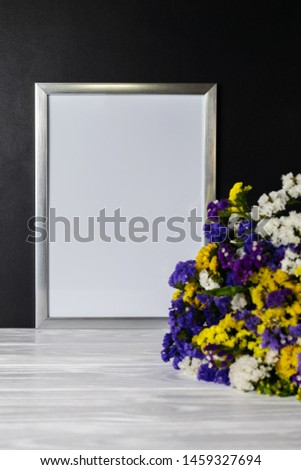 Mock up white frame with bouquet of colorful flowers on a blackboard copy space for text