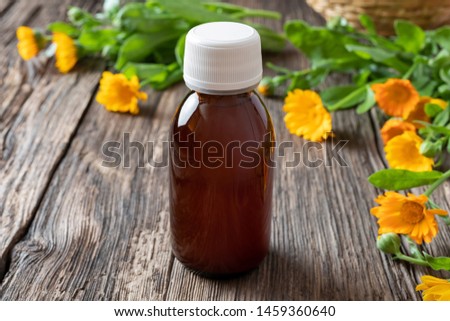 A bottle of herbal tincture with calendula flowers