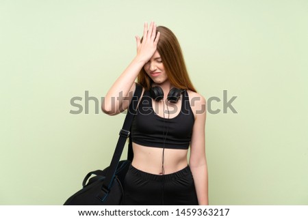 Young sport woman over isolated green background having doubts with confuse face expression