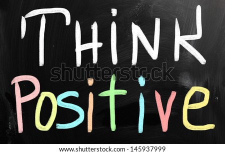 "Think positive" handwritten with white chalk on a blackboard