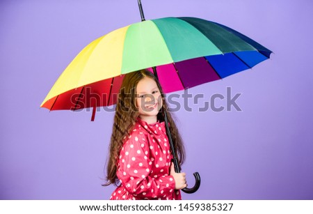 cheerful hipster child in positive mood. rain protection. Rainbow. happy little girl with colorful umbrella. little girl in raincoat. autumn fashion. Happiness highlights her beauty.