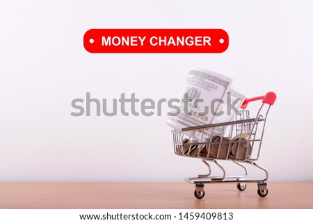 Money changer concept with coin in small trolley and us dollar