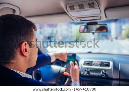 Reckless businessman driving in the city during the rush hour while talking on his phone. Royalty-Free Stock Photo #1459410980
