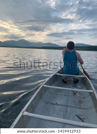 Paddling a canoe on a calm summers day. kayaking in the highlands of scotland. UK. Exploring Nature in a very relaxing way,