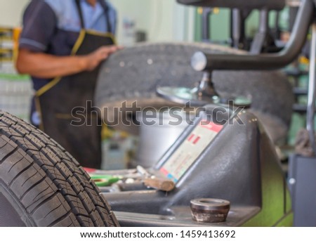 Engineer balancing car wheel on balancer in workshop,focus wheel tire.