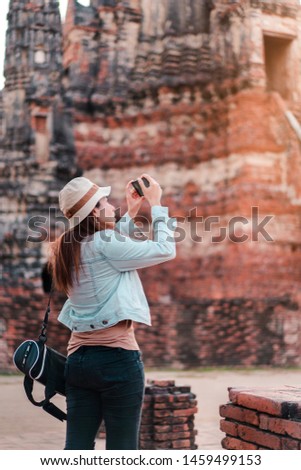 Asia woman take image ancient temple by smarth phone.
