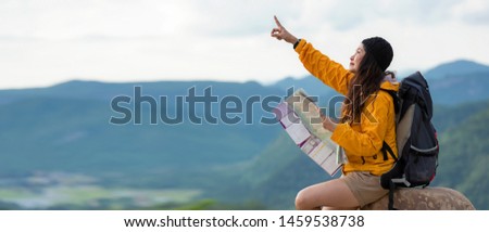 Women hiker or traveler with backpack adventure holding map to find directions and sitting relax on the mountain nature, text for banner and copy space.  Travel and Lifestyle Concept