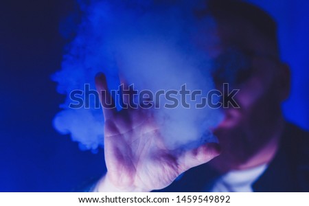 man's hand in smoke. silhouette in neon light