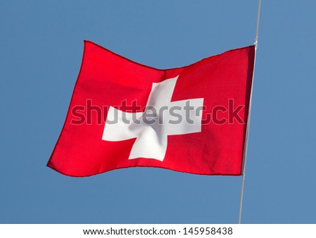Swiss flag in the wind against the sky
