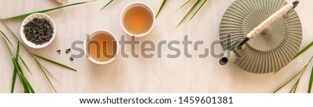 Green Tea Composition with bamboo leaves, banner. Chinese traditional tea set, tea ceremony concept, top view, copy space. Royalty-Free Stock Photo #1459601381