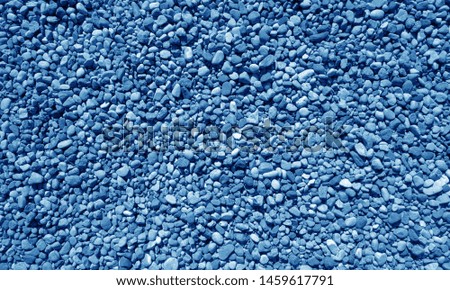 Pile of small gravel stones in navy blue tone. Seasonal natural background.